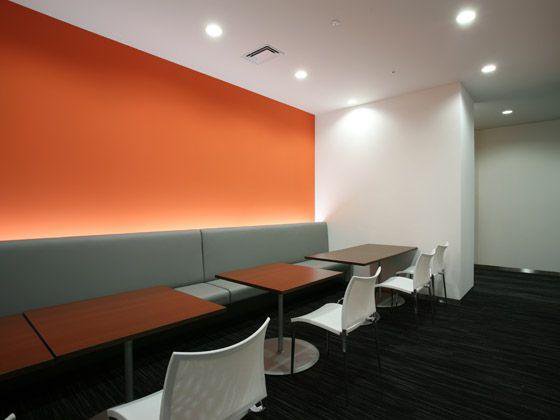 富士通エンジニアリングテクノロジーズ株式会社様の納入事例／【エントランスエリア】壁面が印象的なカフェ形式の待合スペース。