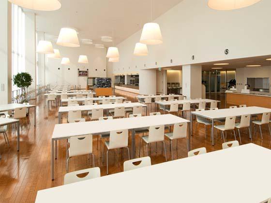 コカ・コーラウエスト株式会社様の納入事例／【食堂】大きな吹き抜けの食堂は清潔感と暖かさを感じる空間。