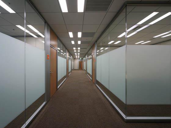 総合素材メーカー様の納入事例／【会議室エリア】ガラスの間仕切りを使用した開放感のある来客エリア内の会議室廊下。