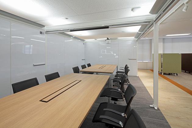 医薬品製造企業様の納入事例／【セミクローズミーティングスペース】間接照明とスクリーンで個室のような領域を生み出す。