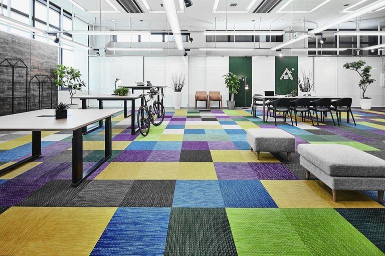 アドヴァン株式会社様の納入事例／【執務スペース】華やかな色味の床材を使用したカジュアルなスペース。実物の色を確認しながら提案活動が可能。
